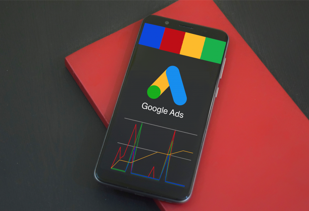 A black phone on a red book displaying the Google ads logo symbolizing the google ads alpha strategy and marketing offer