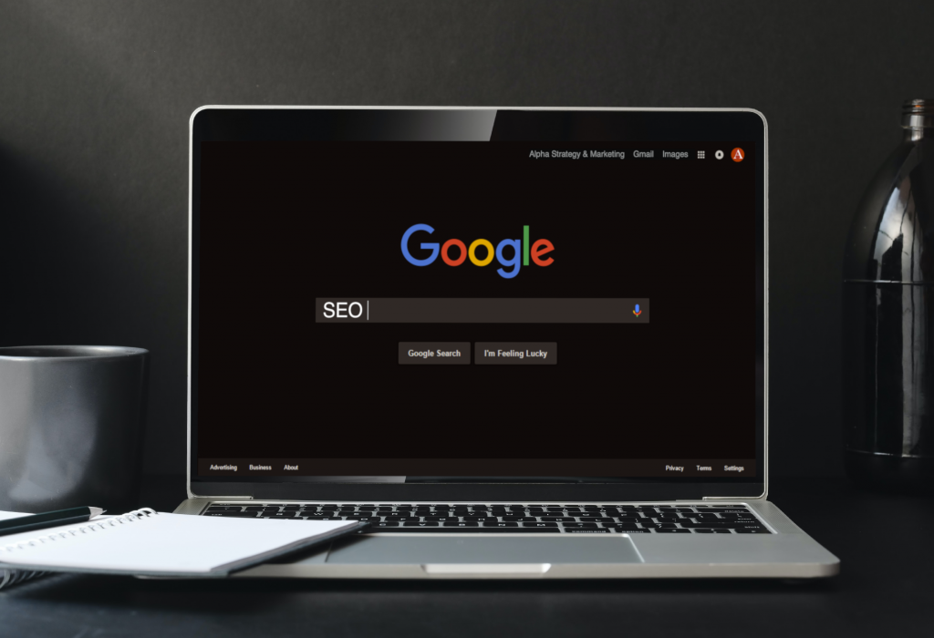 A latop on a desk displaying the Google Search page and SEO has been entered in the search bar.